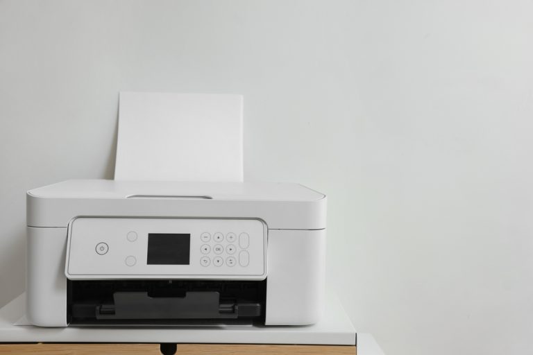 Modern,Printer,With,Paper,On,Table,Near,White,Wall,,Space